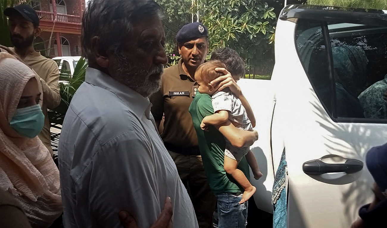 Police personnel escort British-Pakistani children (R) and their grandfather Muhammad Sharif (3L) after appearing in a local court in Jhelum, Pakistan on September 12, 2023. (Photo courtesy: AFP)