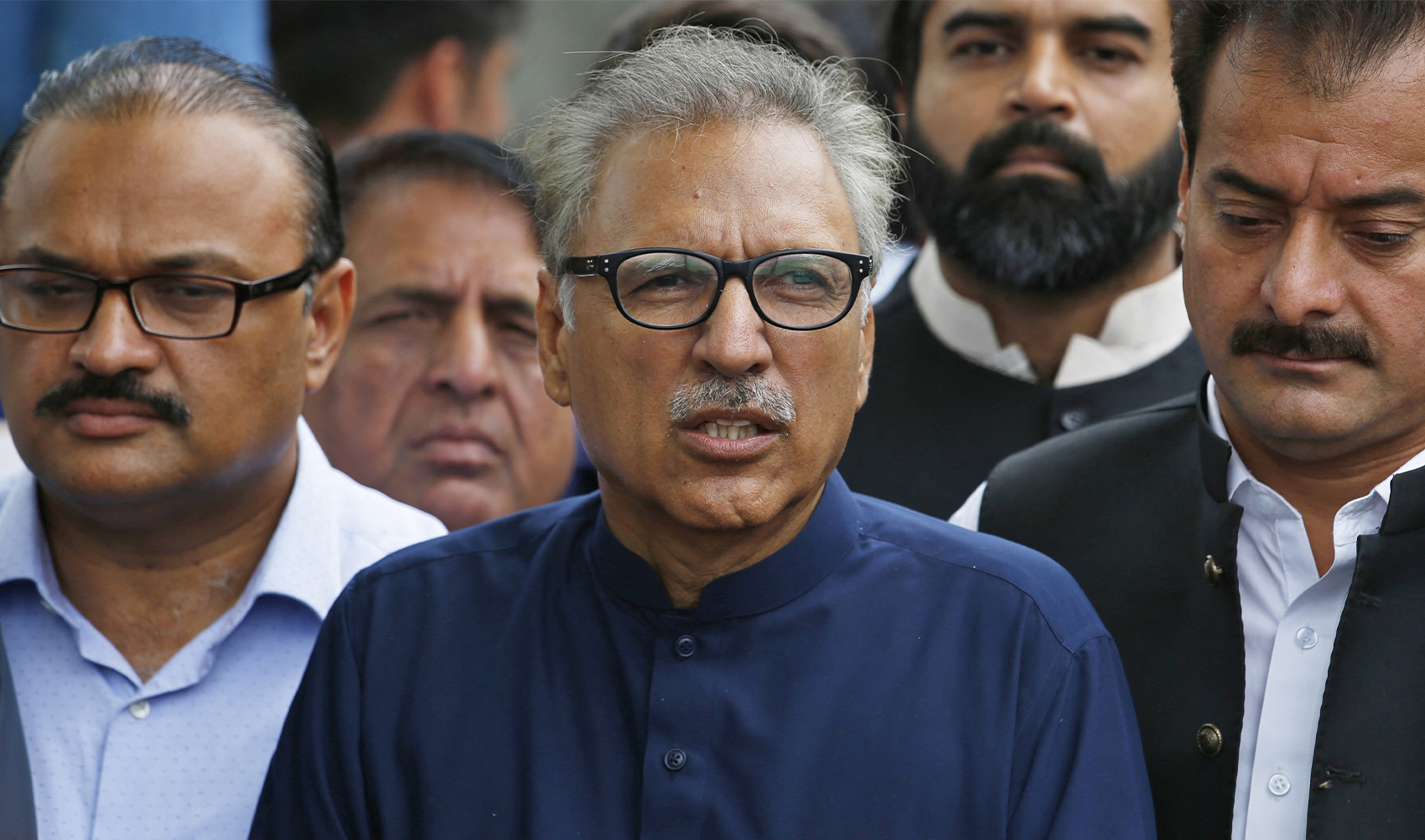 Pakistan's President Dr. Arif Alvi (C) walks back after submitting papers for the presidential election outside the high court building in Islamabad on August 27, 2018. (Photo courtesy: AFP/File)