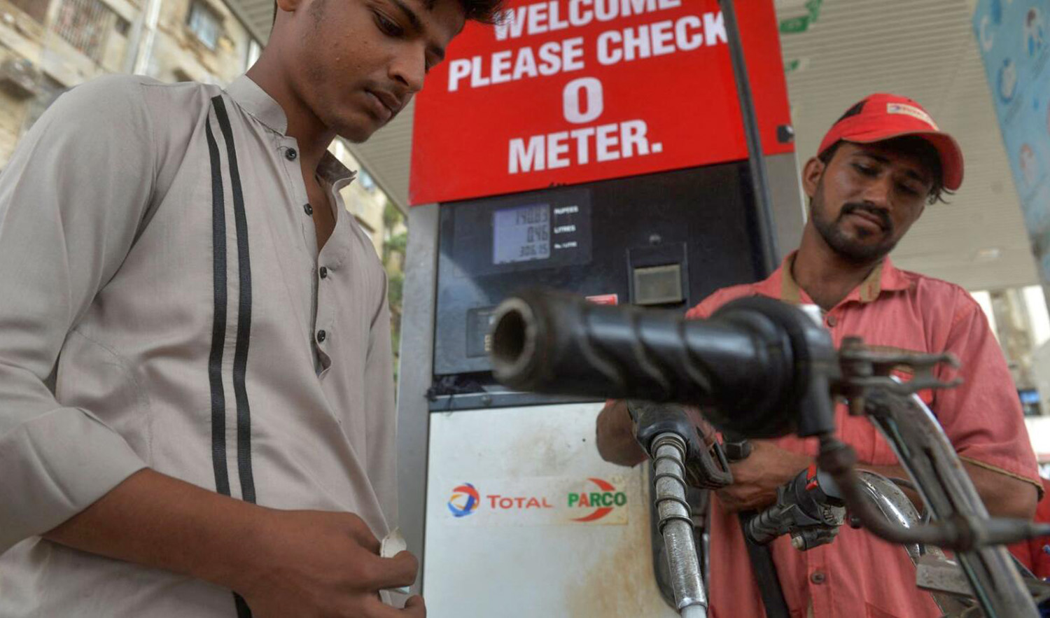 An employee fills petrol in a plastic bottle at a fuel station in Karachi, Pakistan, on September 1, 2023. (AFP/File