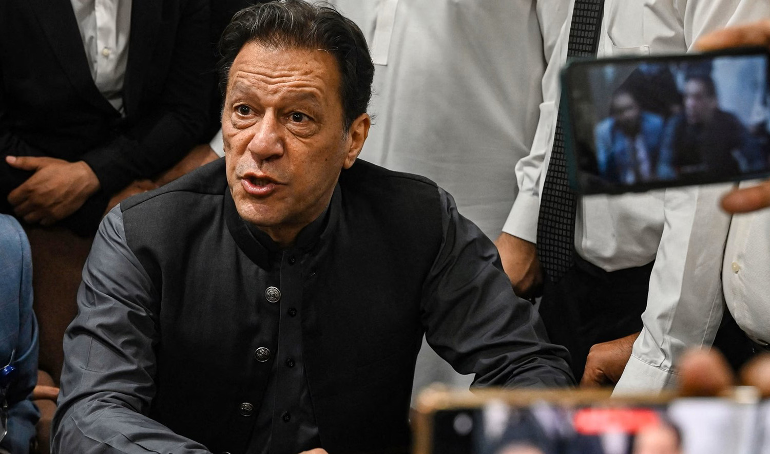 Pakistan's former prime minister, Imran Khan gestures after arriving at a registrar office in Lahore High court to sign surety bonds for bail in various cases, in Lahore on July 3, 2023. (AFP/File)