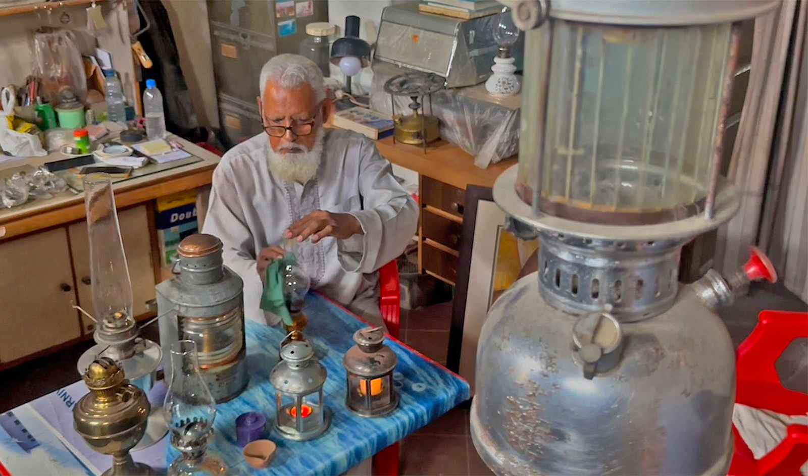 Ahmed Anver, a 67-year-old artist, cleans an old lamp in a museum at his house in Karachi, Pakistan on September 23, 2023. (AN photo)