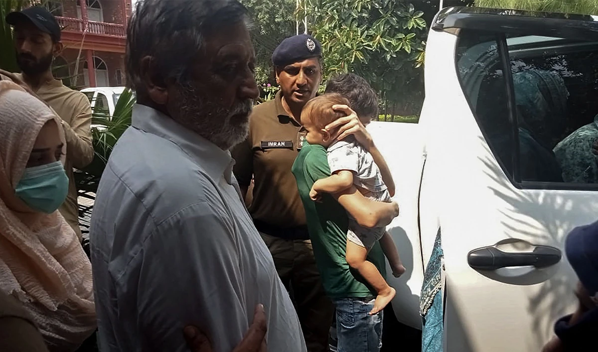 Police personnel escort British-Pakistani children (R) and their grandfather Muhammad Sharif (3L) after appearing in a local court in Jhelum, Pakistan on September 12, 2023. (Photo courtesy: AFP)