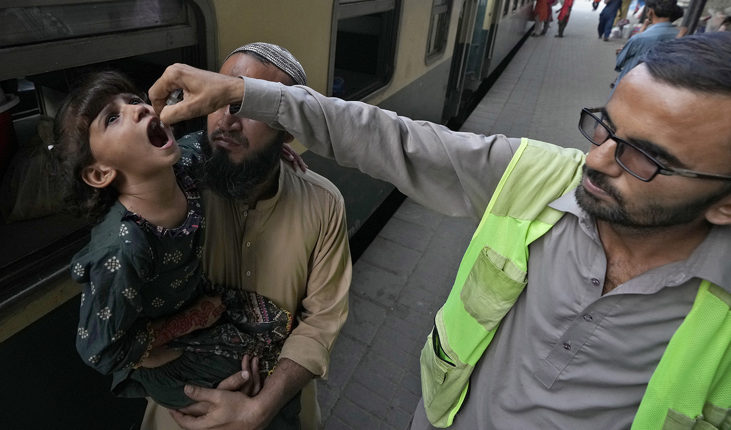 A health worker administers a polio vaccine to a child at a railway station in Karachi, Pakistan, on September 18, 2023. (AP)