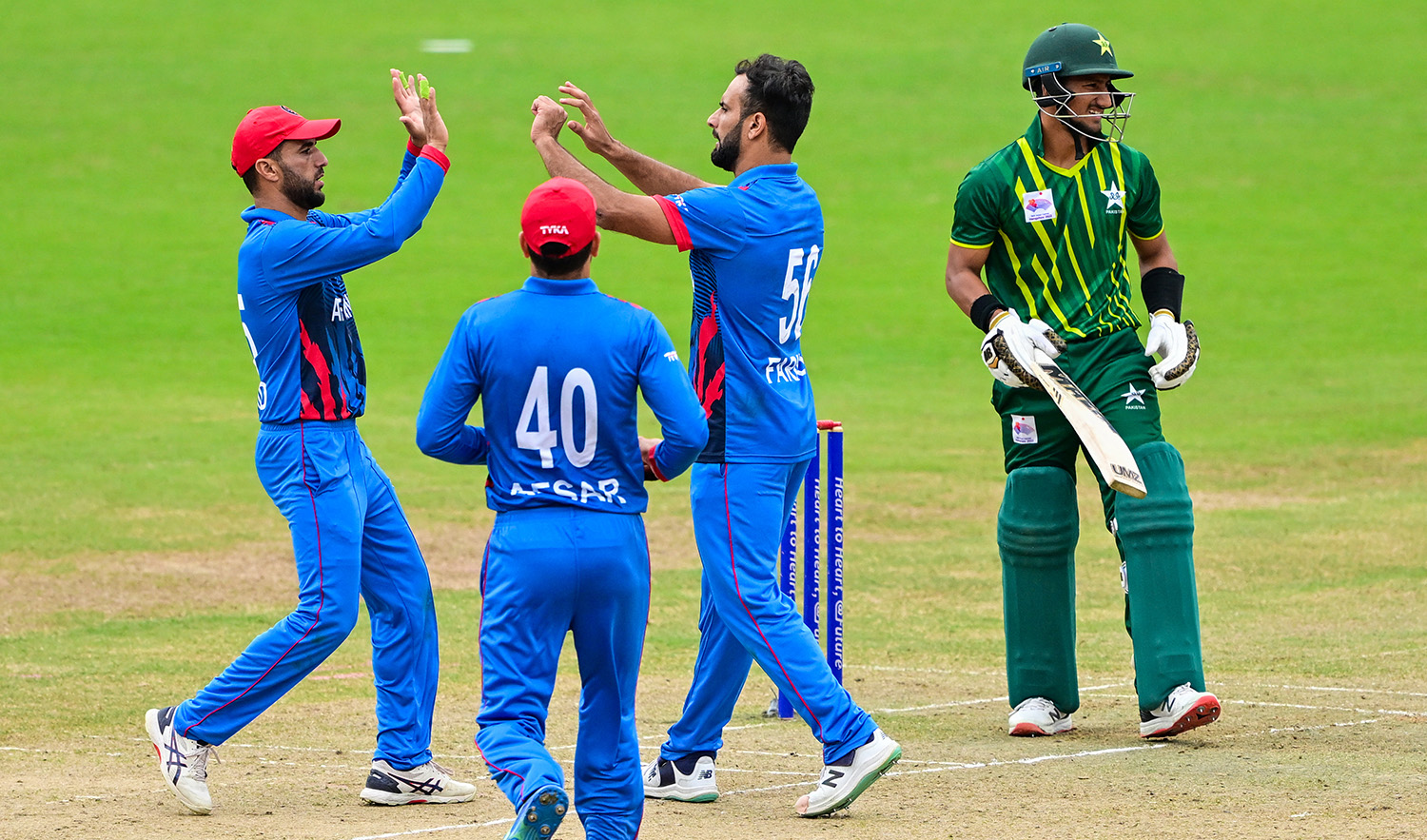 Afghanistan’s Fareed Ahmad, second right, celebrates with teammates after the dismissal of Pakistan's Rohail Nazir during the 2022 Asian Games men’s second semi-final cricket match in Hangzhou, China on October 6, 2023. (AFP)