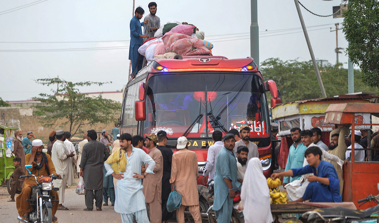 In this photo taken on September 21, 2023, Afghan refugees board a bus from Karachi to Afghanistan. (AFP/File)