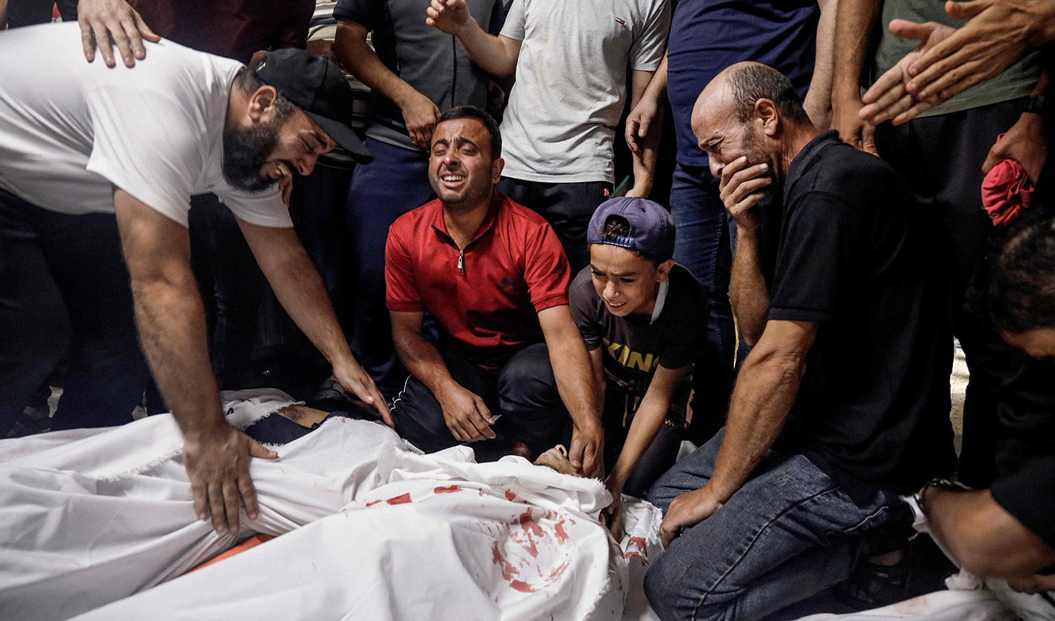 Family members and relatives mourn over the bodies of Palestinians killed in an Israeli attack in Gaza City on October 7, 2023. (AFP)
