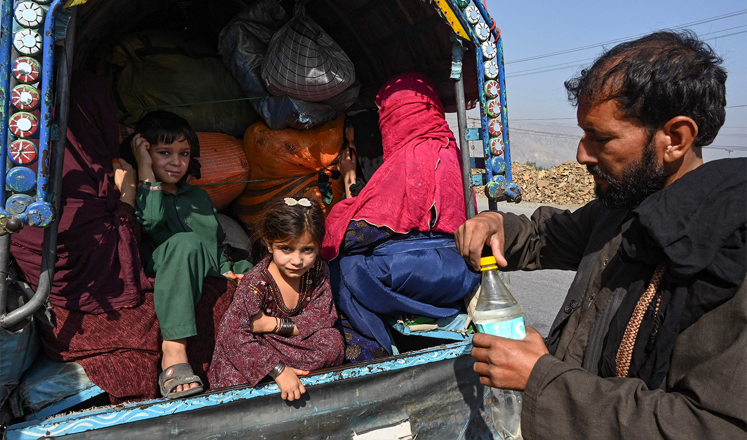 A family of Afghan nationals sit on a vehicle in Jamrud area of Khyber district, some 30 Km west of Peshawar on October 6, 2023, as they return to Afghanistan following Pakistan's government decision to expel people illegally staying in the country. (AFP)
