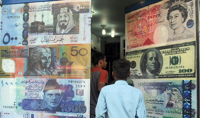 In this file photo taken on October 14, 2010, Pakistani customers enter a foreign currency exchange shop in Karachi. (AFP/File)