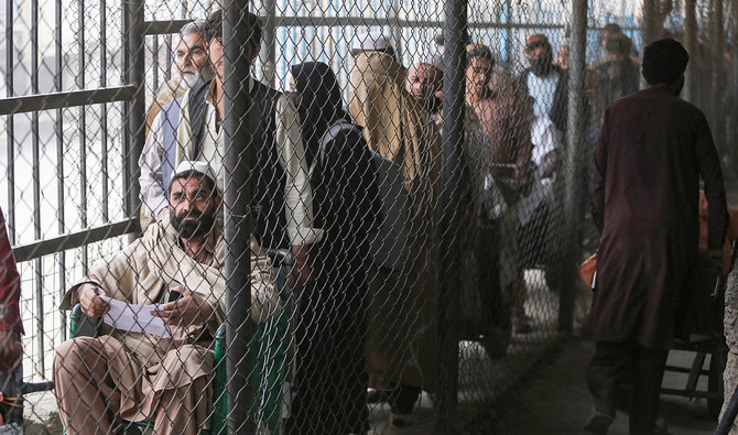 Afghan people wait behind a fenced corridor before crossing into Pakistan at the zero point Torkham border crossing between Afghanistan and Pakistan, in Nangarhar province on February 25, 2023. (AFP/File)