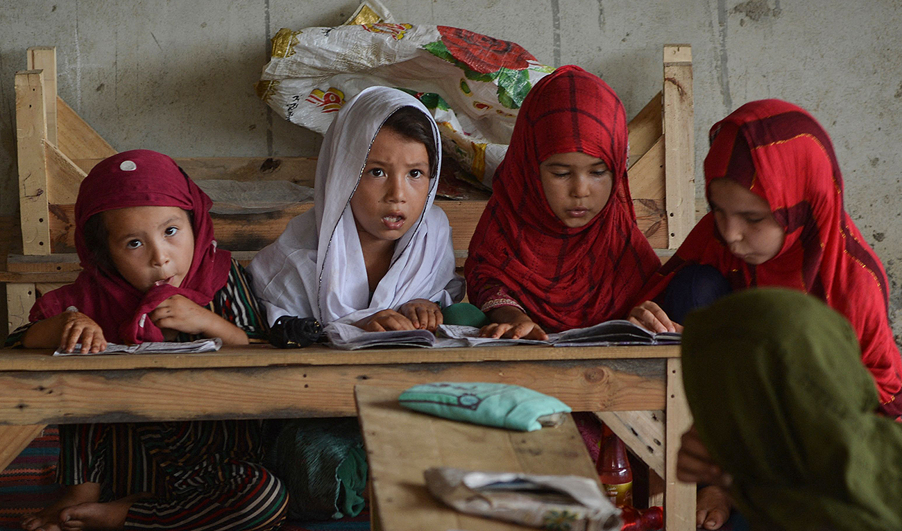 In this photo taken on September 21, 2023, Afghan girls read the Qur'an at an Afghan refugee camp in Karachi. (AFP)