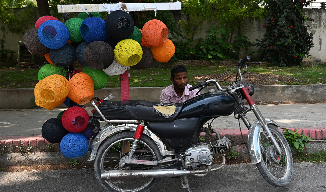 A vendor selling lamp shades waits for customers along a road in islamabad, Pakistan, on May 3, 2023. (AFP/File)