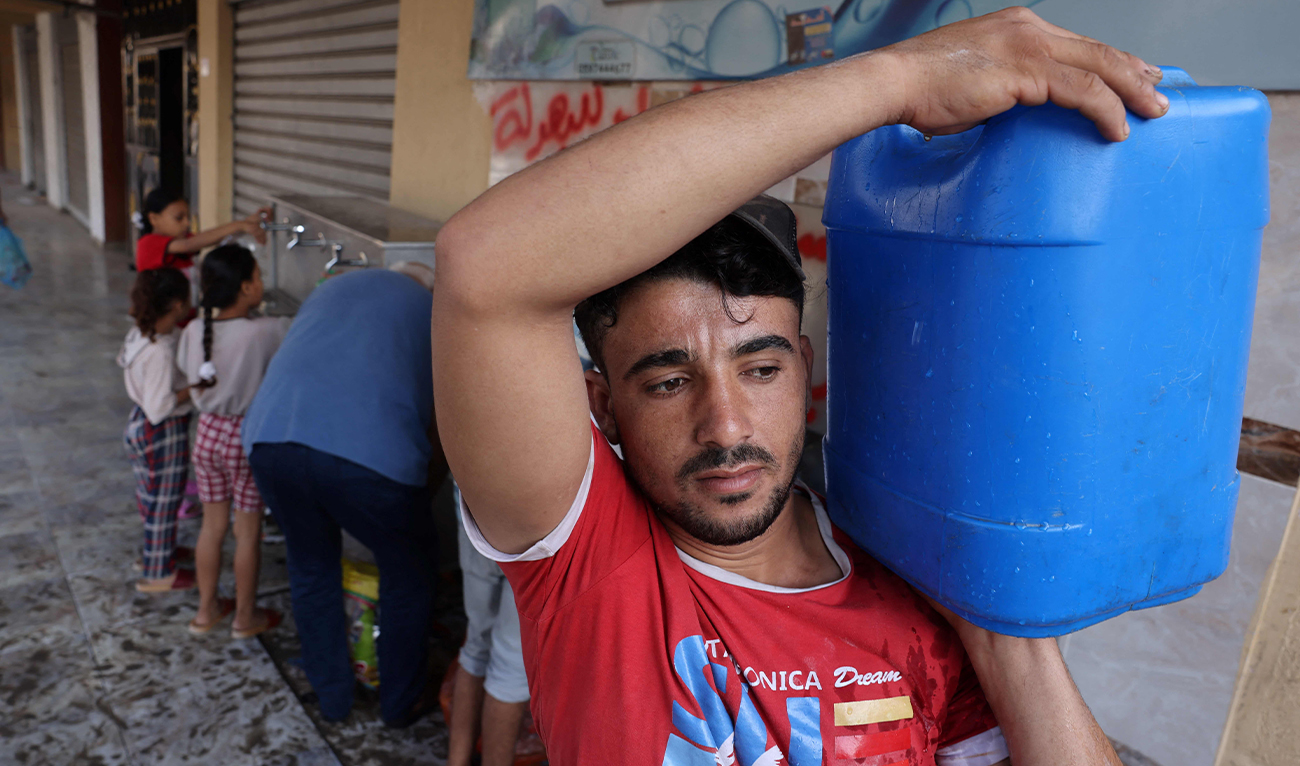 A Palestinian man collects water from a public water collection point, as raging battles between Israel and the Hamas movement continue for the sixth consecutive day in Gaza City on October 12, 2023. (AFP)