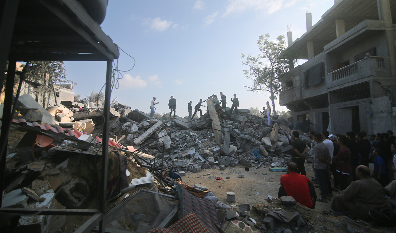 Palestinians stand by the building destroyed in an Israeli airstrike in Rafah, Gaza Strip, on October 14, 2023. (AP)
