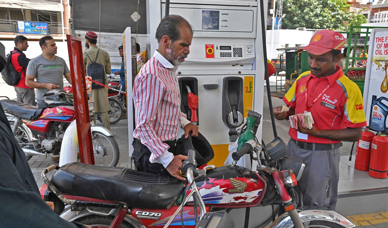 An employee fills petrol in a motorcycle at a fuel station in Lahore, Pakistan, on August 1, 2023. (AFP/File)