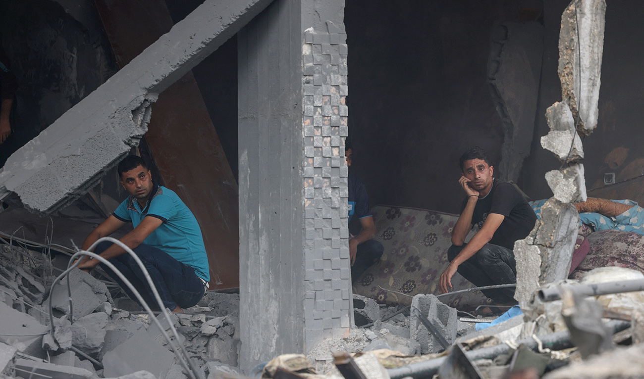 Palestinian men look on as they sit on rubble after Israeli strikes in Rafah in the southern Gaza Strip on October 23, 2023, amid ongoing battles between Israel and the Palestinian Hamas group. (AFP)