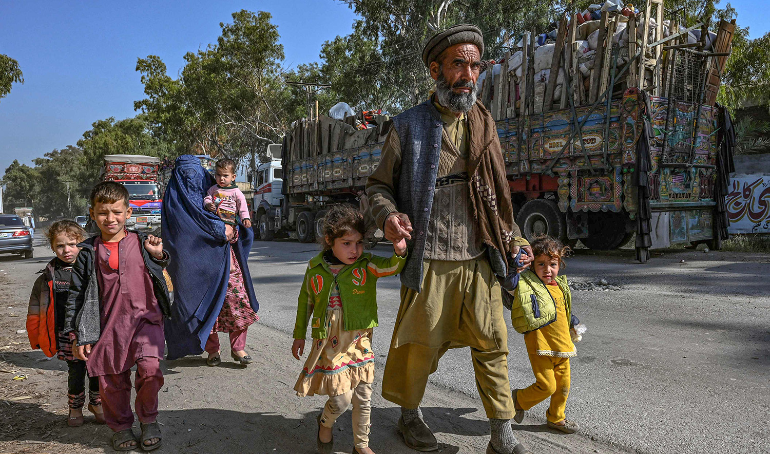 An Afghan refugee family living in Pakistan arrives outside the United Nations High Commissioner for Refugees (UNHCR) repatriation center, some 25 Km from Peshawar on October 25, 2023. (AFP)