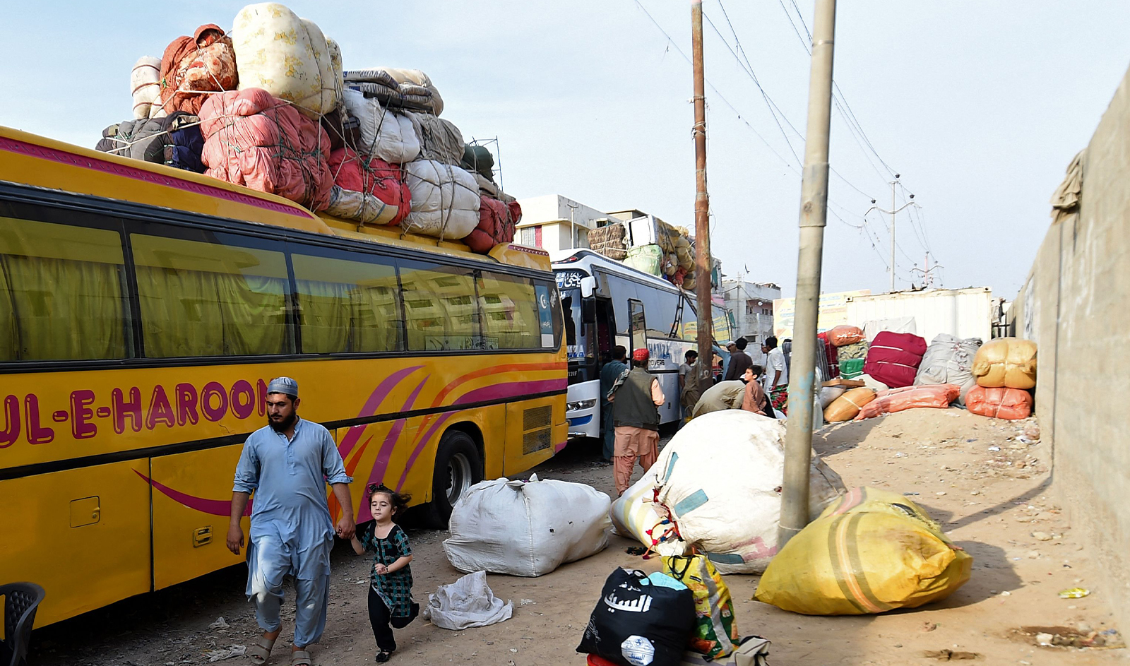Pakistan's Afghan refugees load their belongings onto a bus at the Karachi bus terminal in Sindh province for their departure to Afghanistan on October 27, 2023. (AFP)