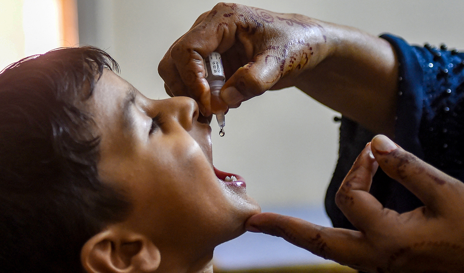 A health worker administers polio drops to a child during a door-to-door vaccination campaign in Karachi, Pakistan on October 2, 2023. (AFP)