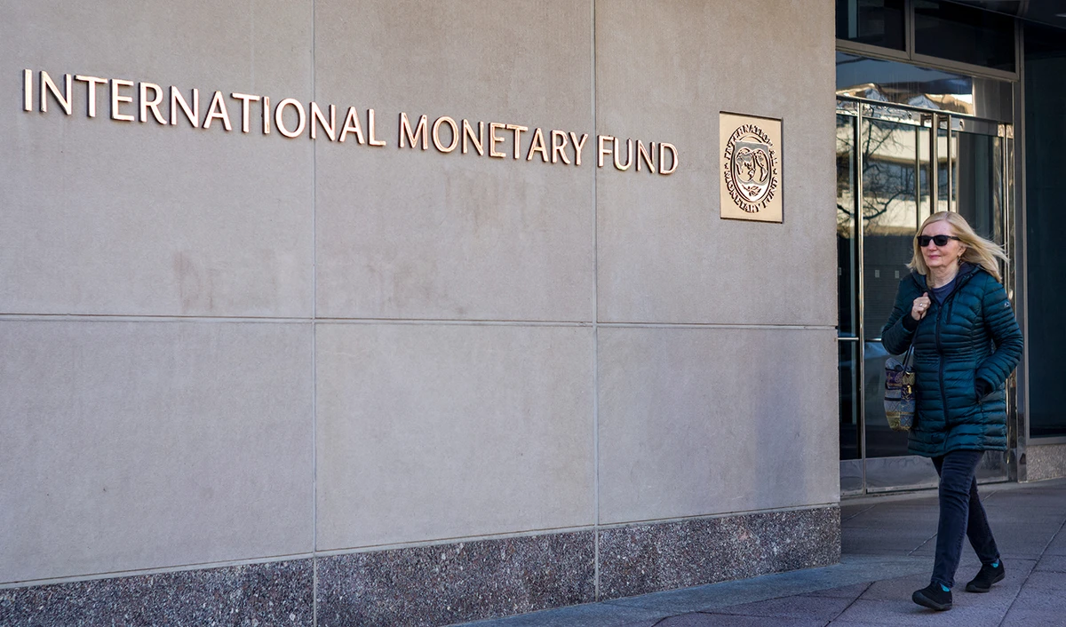A woman walks past the International Monetary Fund (IMF) headquarters building in Washington, DC on March 11, 2022. (AFP/File)