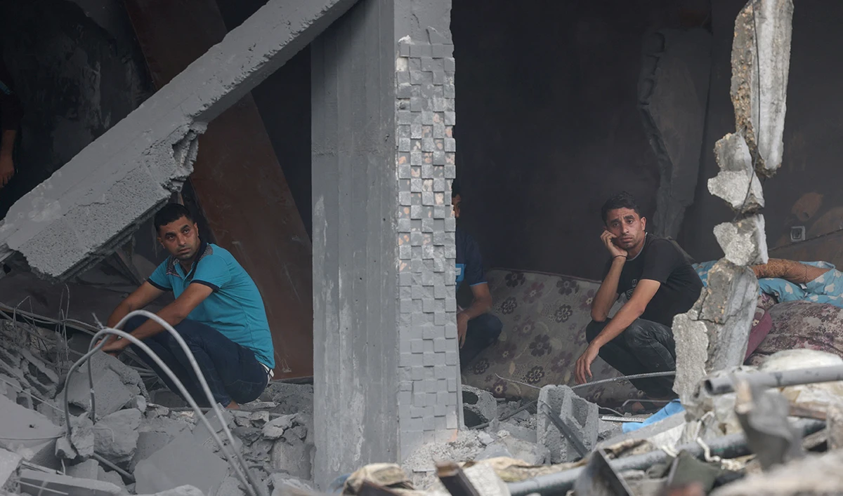 Palestinian men look on as they sit on rubble after Israeli strikes in Rafah in the southern Gaza Strip on October 23, 2023, amid ongoing battles between Israel and the Palestinian Hamas group. (AFP)