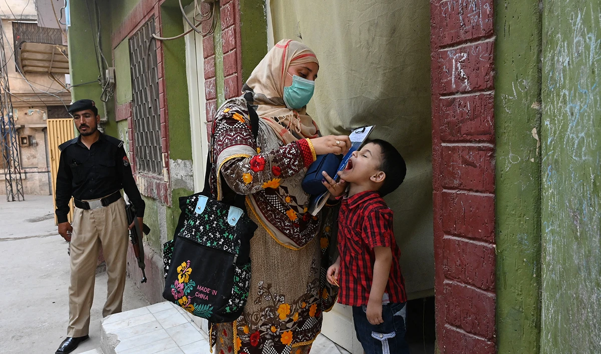 A health worker administers polio vaccine drops to a child during a vaccination campaign in Peshawar on May 22, 2023. (AFP/File)