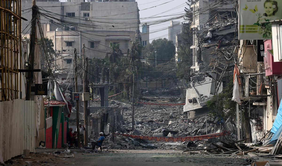 Graphic content / TOPSHOT - A man sits in front of buildings destroyed by Israeli strikes in Gaza City on October 28, 2023. (AFP/File)