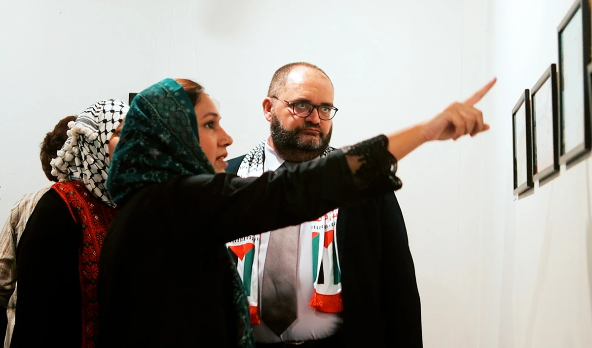 Nader AlTurk, Deputy head of Palestine mission in Pakistan (right), speaks with organizers and artists at Lok Virsa gallery in Islamabad, Pakistan on October 28, 2023. (AN Photo)