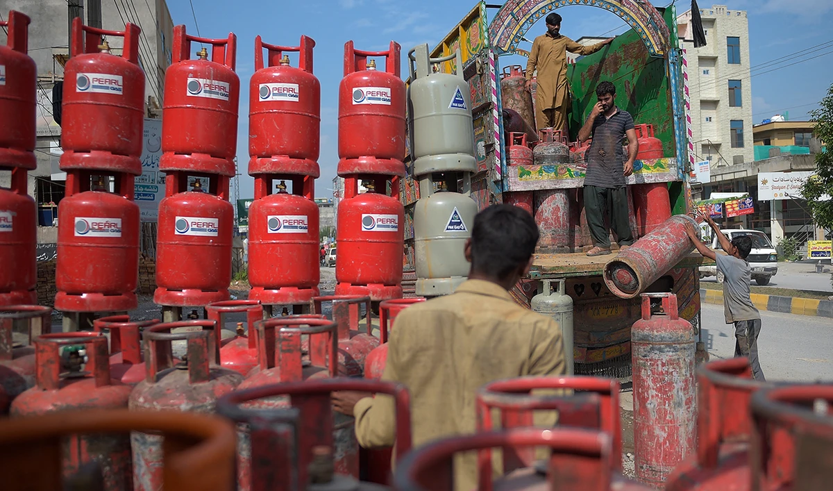 Labourers unload gas calendar from a truck at a market on the outskirts of Islamabad on September 2, 2020. (AFP/File)