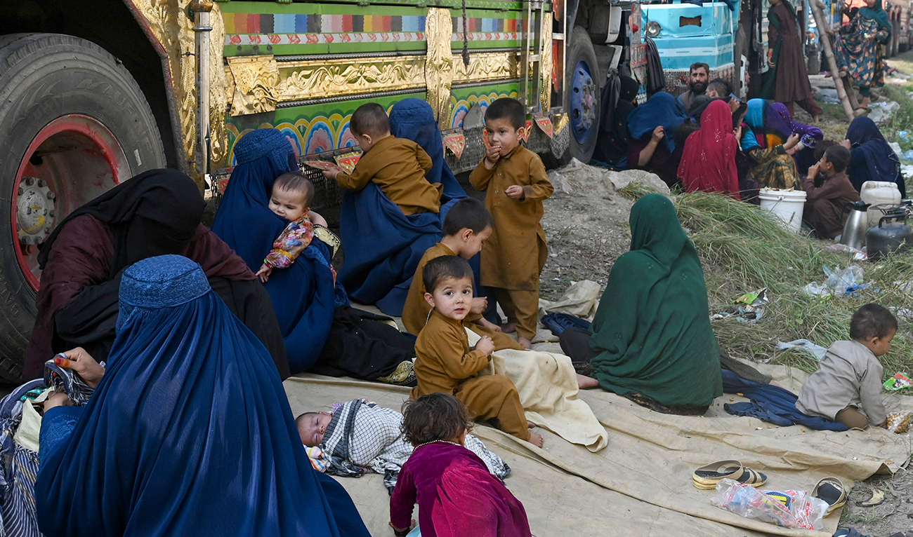 Afghan refugees wait near the United Nations High Commissioner for Refugees (UNHCR) Azakhel Voluntary Repatriation Centre in Nowshera on October 30, 2023. (AFP)