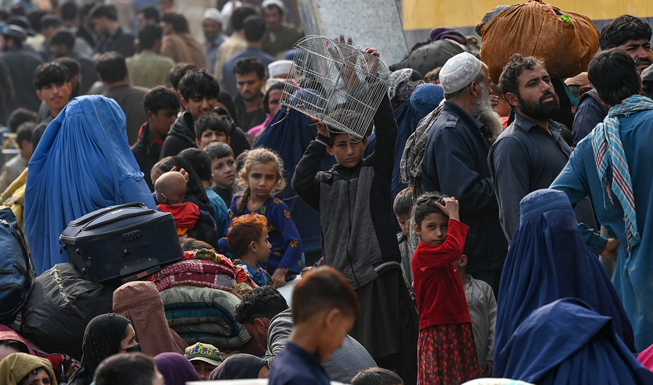 Afghan refugees carry their belongings at the Afghanistan-Pakistan Torkham border as they arrive from Pakistan, in Nangarhar province on November 1, 2023. (AFP)