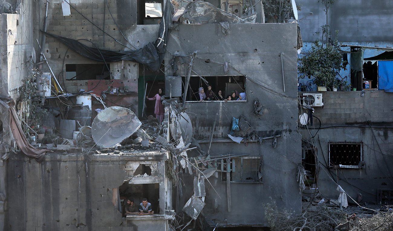 Palestinians look from windows at the damage caused by Israeli airstrikes in Jabaliya refugee camp, northern Gaza Strip on November 1, 2023. (AP)