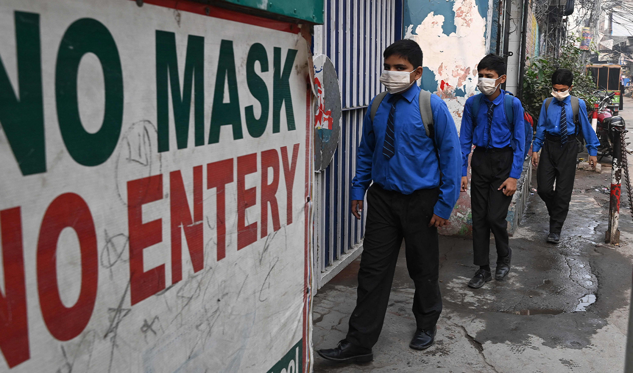 Students wearing facemasks arrive at a school in Lahore on November 2, 2023, following Punjab's government announcement to use facemasks due to severe smoggy conditions. (AFP)