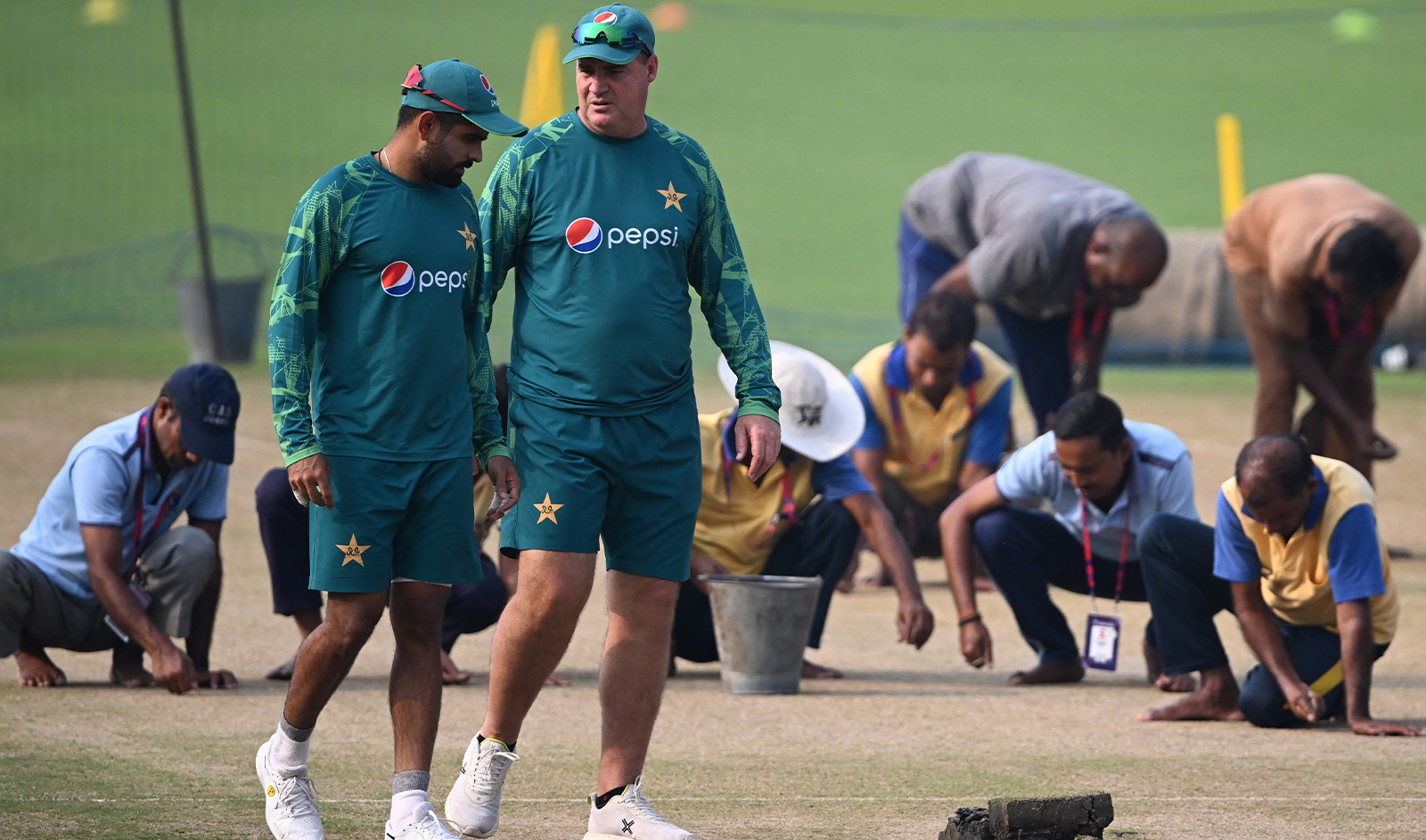 Pakistan’s captain Babar Azam (2L) with coach Mickey Arthur inspect the pitch during a practice session at the Eden Gardens in Kolkata on October 30, 2023, on the eve of their 2023 ICC Men's Cricket World Cup one-day international (ODI) match against Bangladesh. (AFP/File)