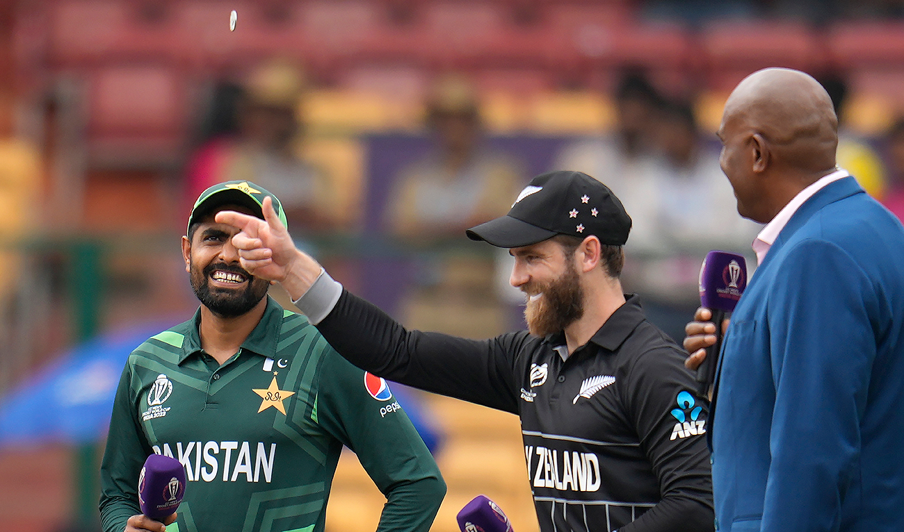 New Zealand's captain Kane Williamson tosses a coin as Pakistan's captain Babar Azam watches before the start of the ICC Men's Cricket World Cup match between New Zealand and Pakistan in Bengaluru, India, Saturday, Nov. 4, 2023. (AP)