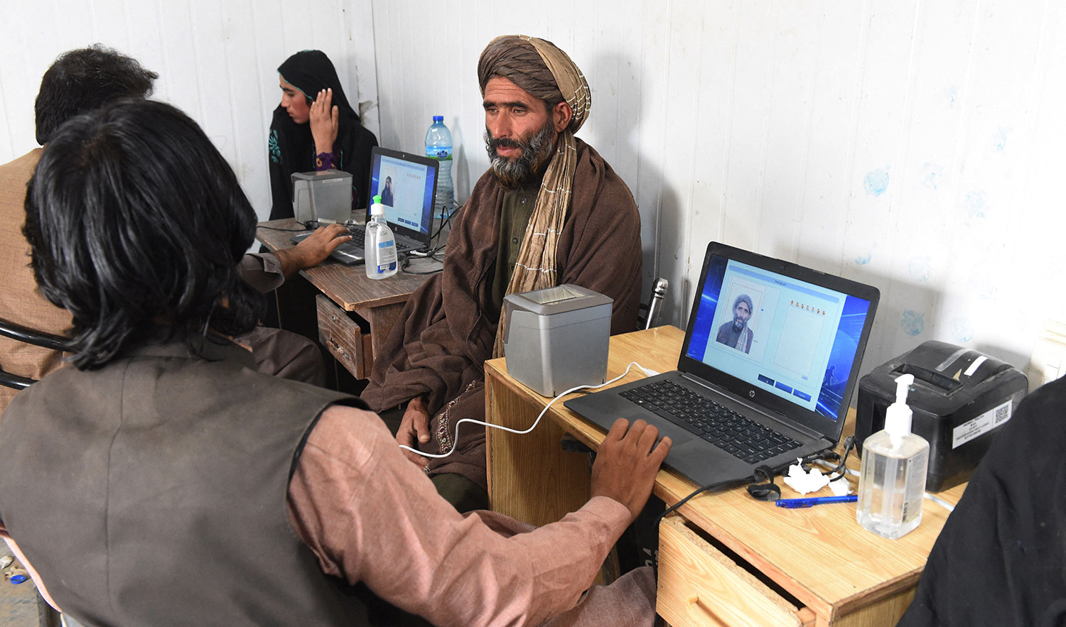 Afghan refugees provide biometric verification to an official of the National Database and Registration Authority (NADRA) at a holding centre near the Pakistan-Afghanistan border in Chaman on November 4, 2023. (AFP)