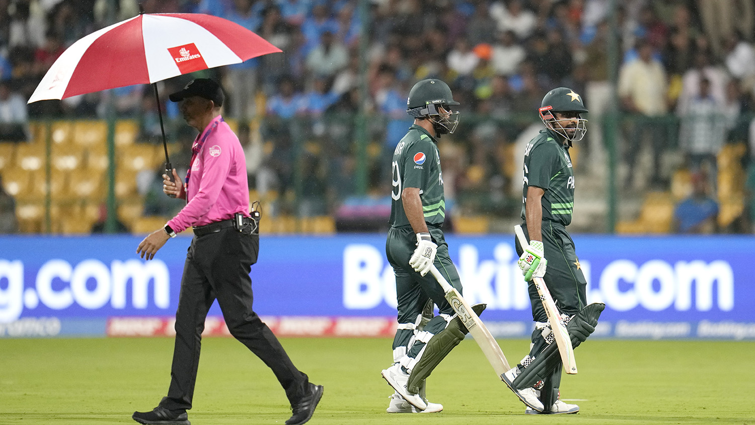 Pakistan's captain Babar Azam and Fakhar Zaman leave the ground after rain interrupted the play during the ICC Men's Cricket World Cup match between New Zealand and Pakistan in Bengaluru, India, on November 4, 2023. (AP)