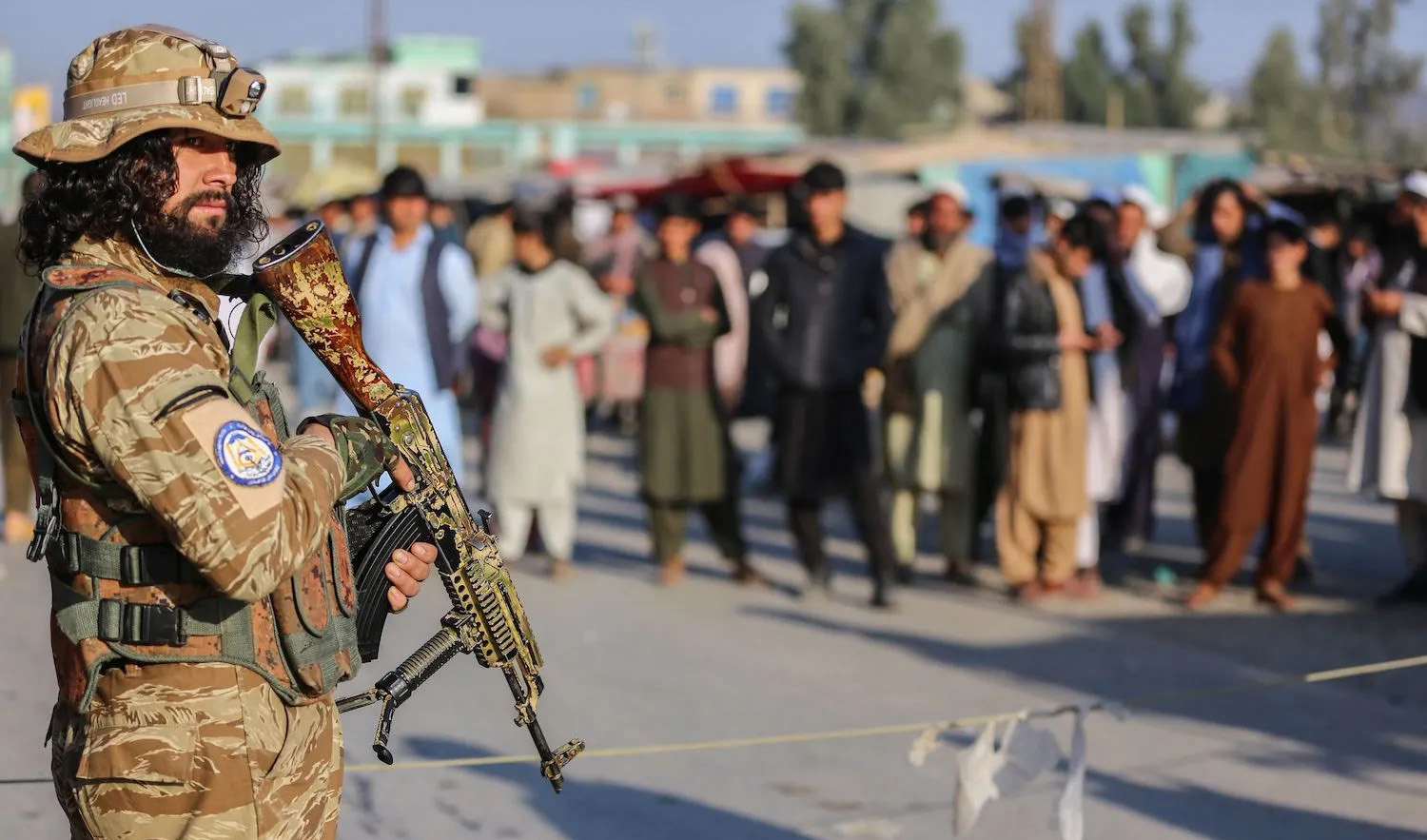 A Taliban security personnel stand guard as Afghan people wait to cross into Pakistan, near the closed Torkham gate at the Torkham border crossing between Afghanistan and Pakistan, in Nangarhar province on February 23, 2023. (AFP/File)