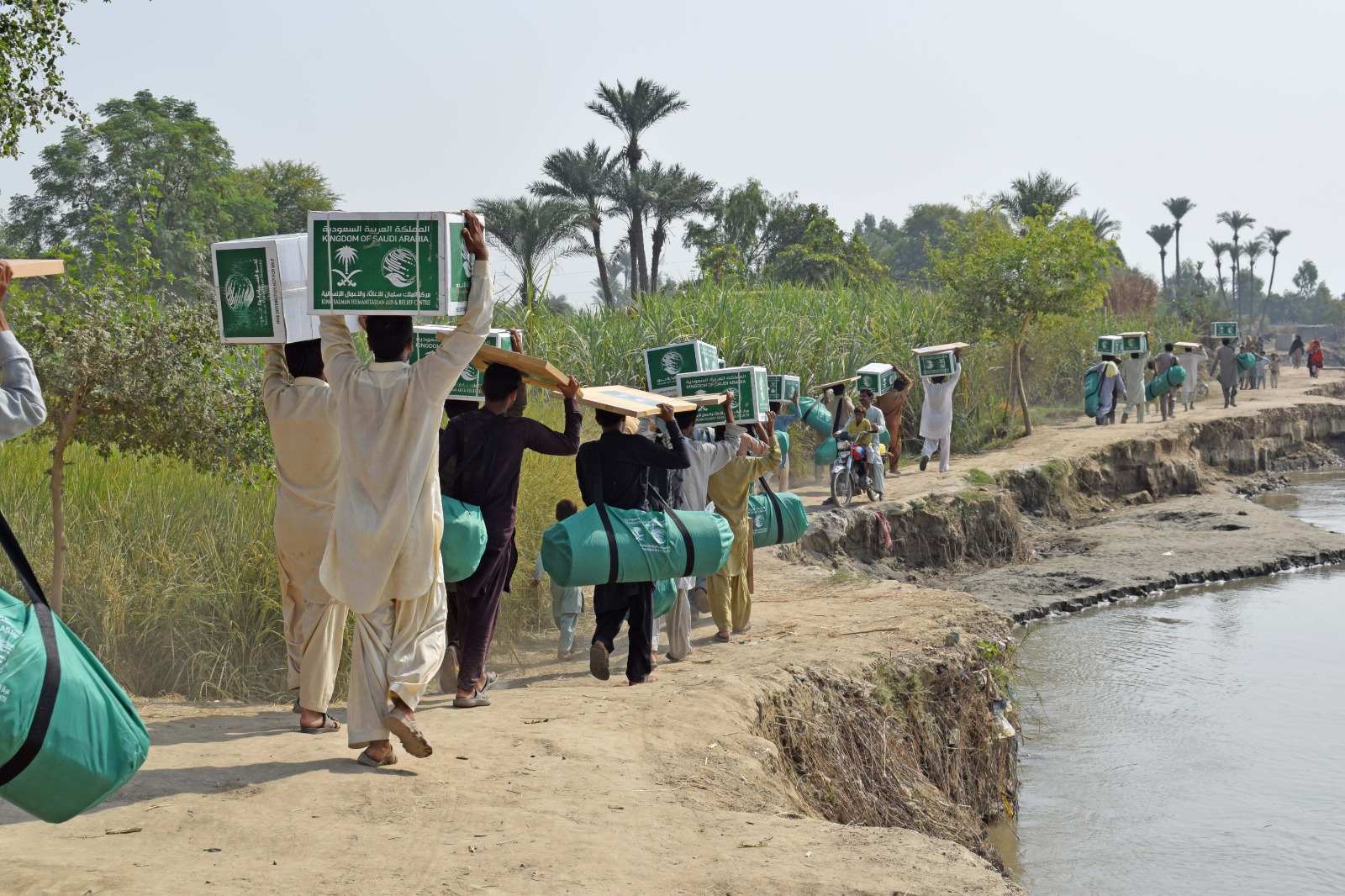 Flood affected people carrying relief items distributed by King Salman Humanitarian Aid and Relief Center (KSRelief) in Layyah, Pakistan on October 15, 2023. (Photo courtesy: KSRelief)