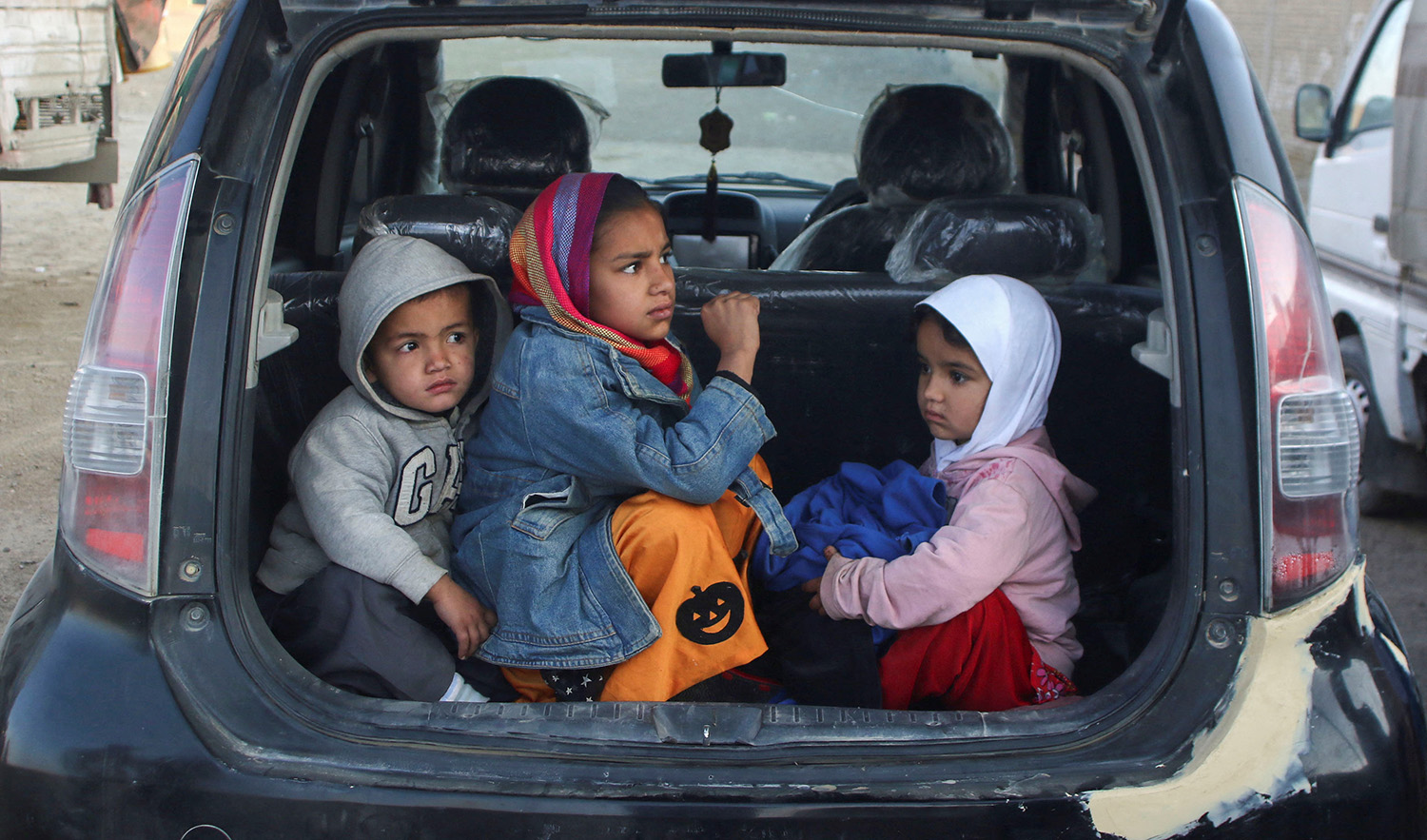 Afghan children sit in the trunk of a family car as they along with others head back to Afghanistan from Pakistan, at the Chaman Border Crossing along the Pakistan-Afghanistan Border in Balochistan Province, in Chaman, Pakistan on November 9, 2023. (REUTERS)