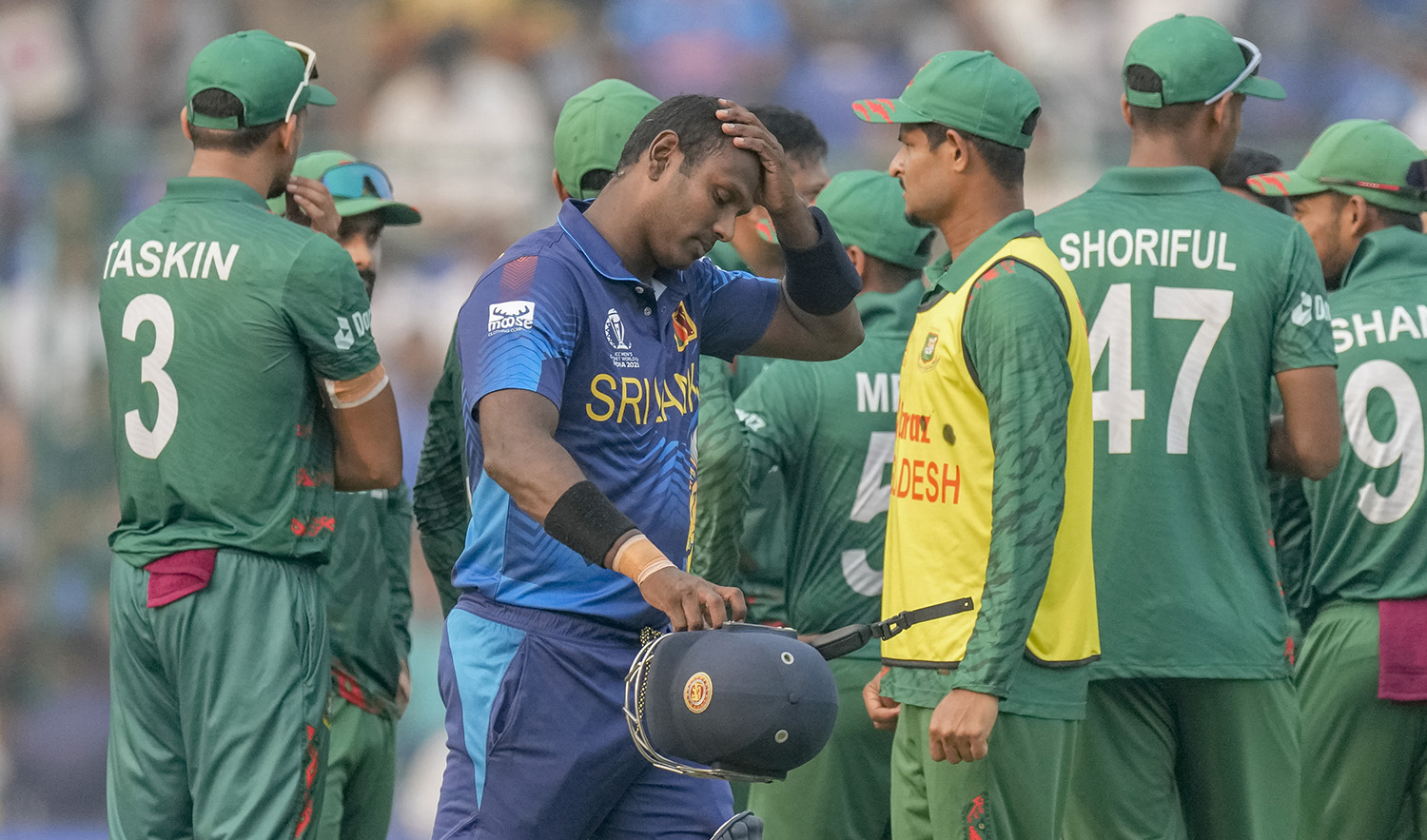 Sri Lanka's Angelo Mathews, foreground walks off the field after he was declared timed out during the ICC Men's Cricket World Cup match between Bangladesh and Sri Lanka in New Delhi, India, on November 6, 2023. (AP)