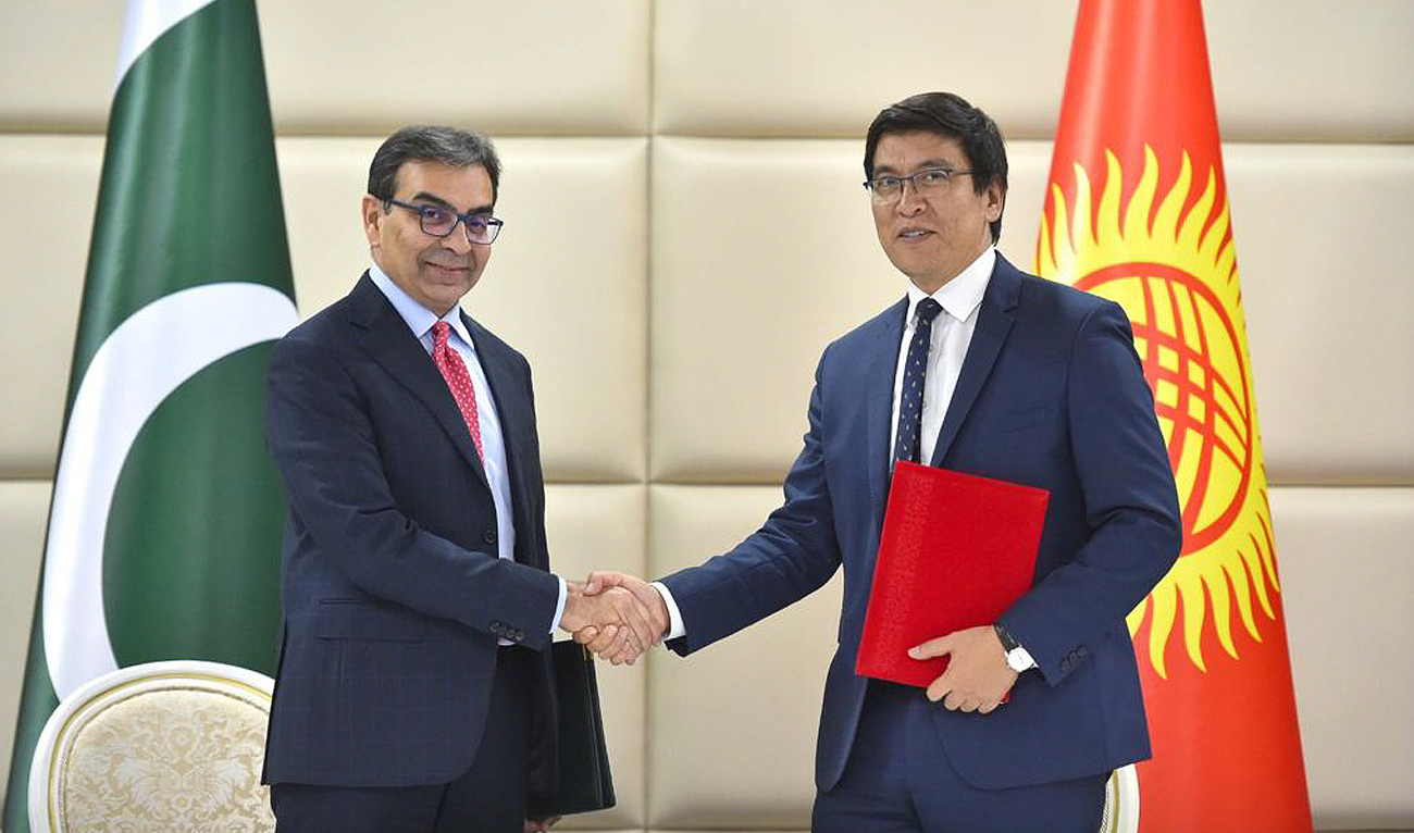 In this handout photograph, taken and released by Pakistan's Ministry of Economic Affairs, Caretaker Energy Minister Muhammad Ali shakes hands with Kyrgyz's Baisalov Edil Zholdubaevich after signing agreements on Trade- Economic and Scientific-Technical Cooperation in Islamabad on November 14, 2023. (Photo courtesy: GOP)