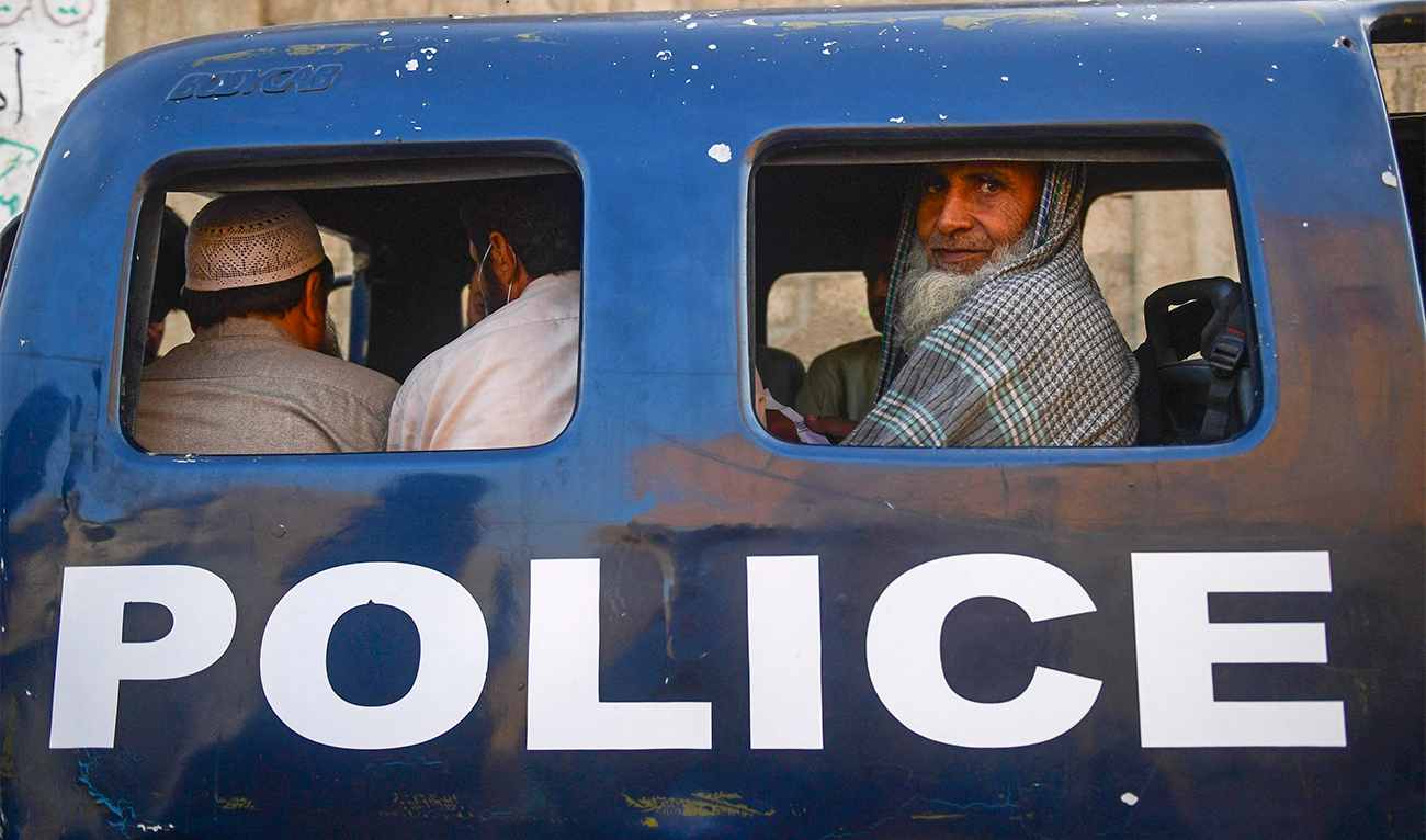 Detained Afghan refugees sit in a van during a search operation to identify alleged illegal immigrants, on the outskirts of Karachi on November 17, 2023. (AFP)