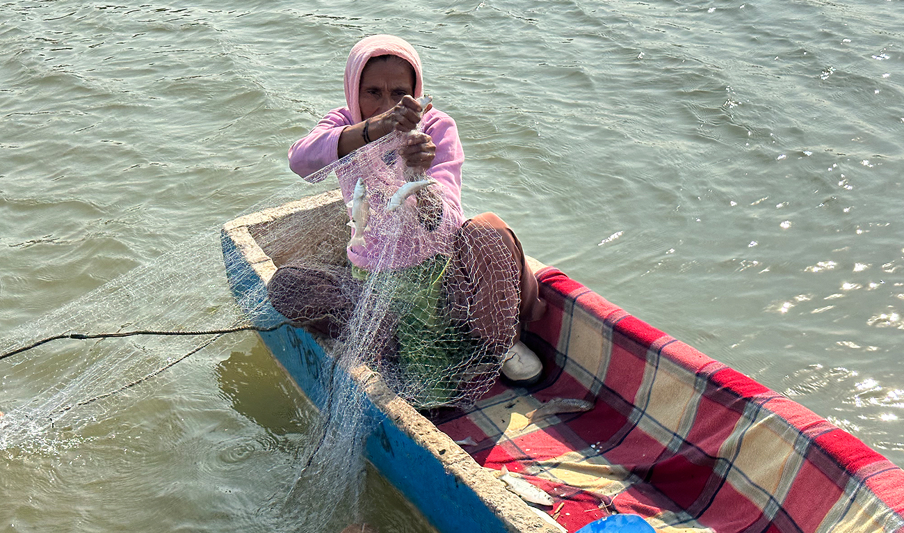 This picture taken on November 15, 2023, shows Pakistani fisherwoman Hakima Omar, 63, displaying a catch in the waters off Rehri Goth coastal village in Karachi. (AN Photo)