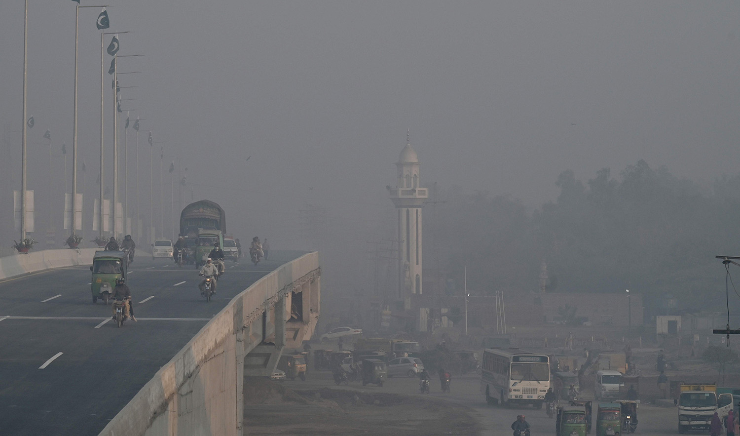 Commuters make their way along a street amid smog in Lahore, Pakistan, on November 17, 2023. (AFP)