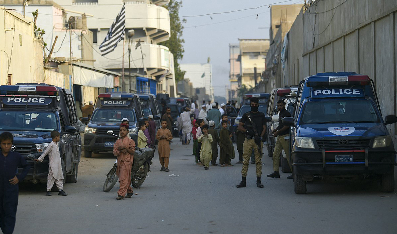 In this photo, taken on November 17, 2023, Police personnel stand guard during a search operation to identify alleged illegal immigrants, on the outskirts of Karachi. (AFP)