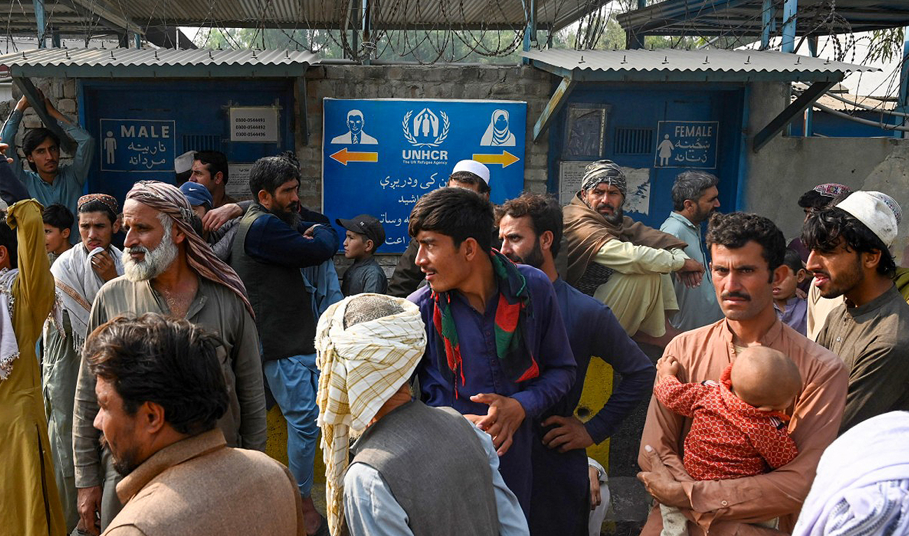Afghan refugees wait near the United Nations High Commissioner for Refugees (UNHCR) Azakhel Voluntary Repatriation Centre in Nowshera on October 30, 2023. (AFP)