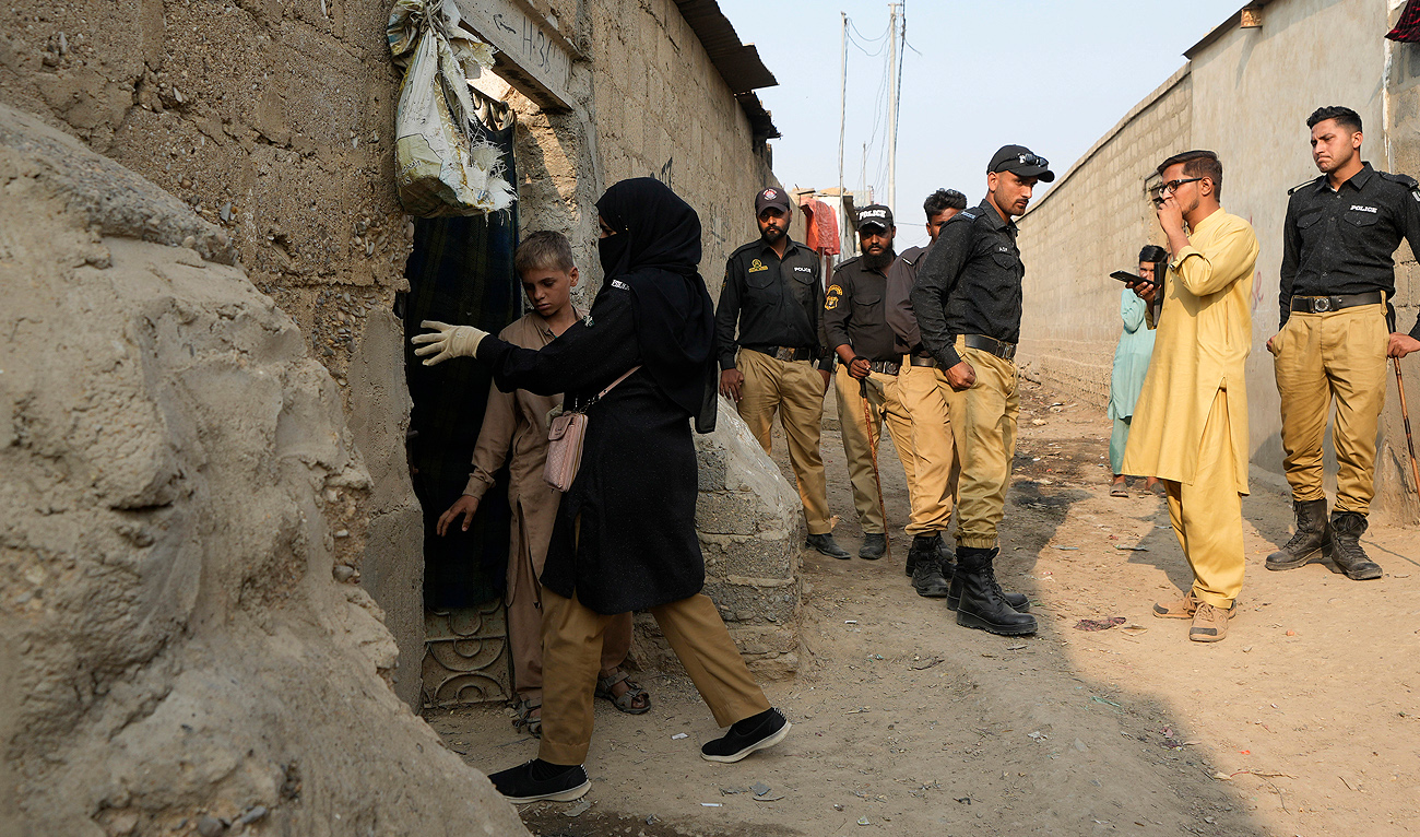 Pakistani police officers conduct biometric identification of residents during a search operation against illegal immigrants in a neighbourhood of Karachi, Pakistan, on Tuesday, Nov. 21, 2023. (AP)