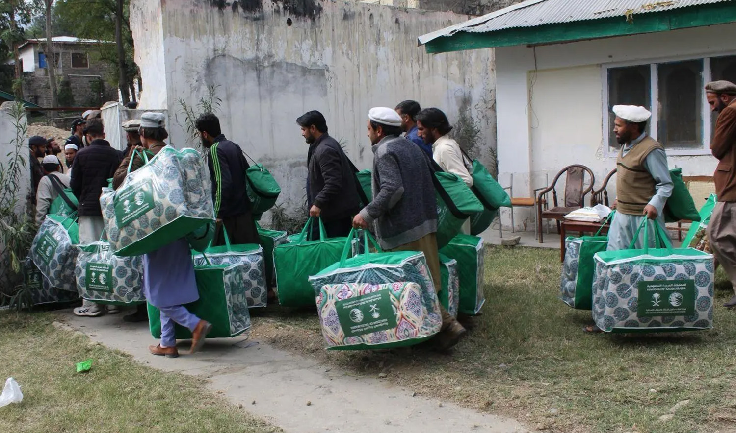 In this undated file photo, people receive aid packages provided by the King Salman Center for Relief and Humanitarian Aid (KSRelief) in Pakistan. (SPA/File)