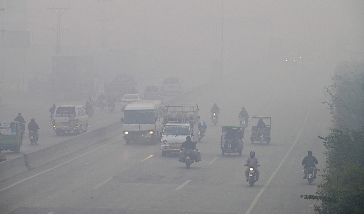 Commuters drive along a road amid dense smog in Lahore, Pakistan on November 24, 2023. (AFP)