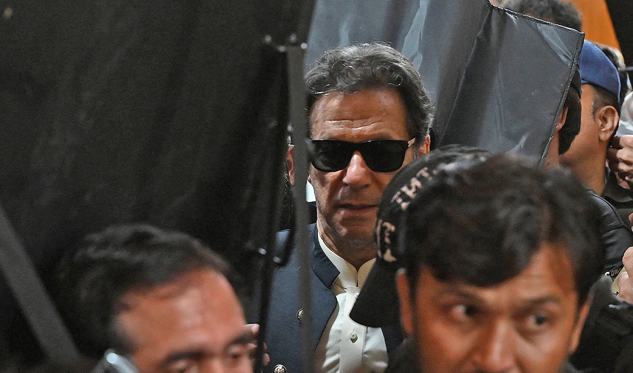 Security personnel with ballistic shields escort former Pakistan's prime minister Imran Khan (C) as he leaves after appearing at the High Court in Lahore on May 19, 2023. (AFP/File)